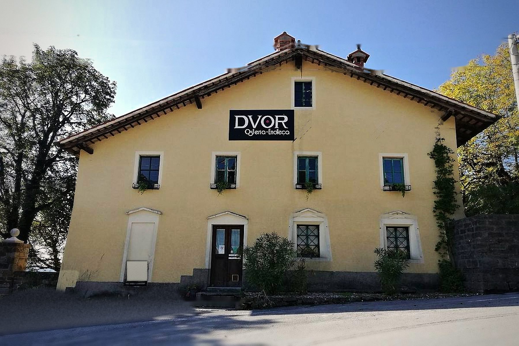 La storica casa gialla che ospita l'Osteria Enoteca Dvor, con l'insegna sopra la porta